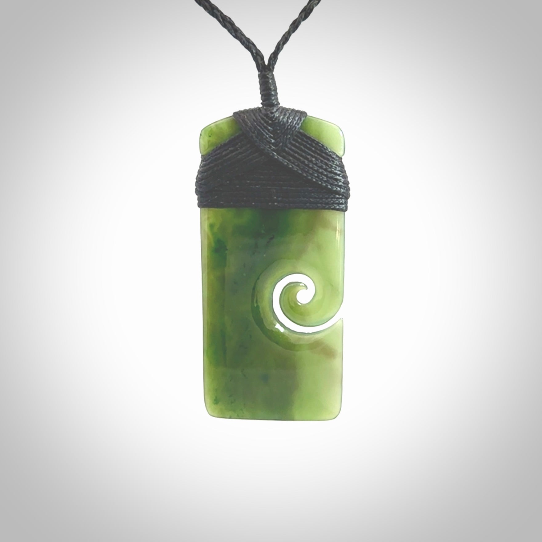 British Coloumbian jade toki koru pendant. Hand carved in New Zealand. Hand made British Coloumbian Jade jewellery. Provided with an adjustable cord and packaged in a woven kete pouch.
