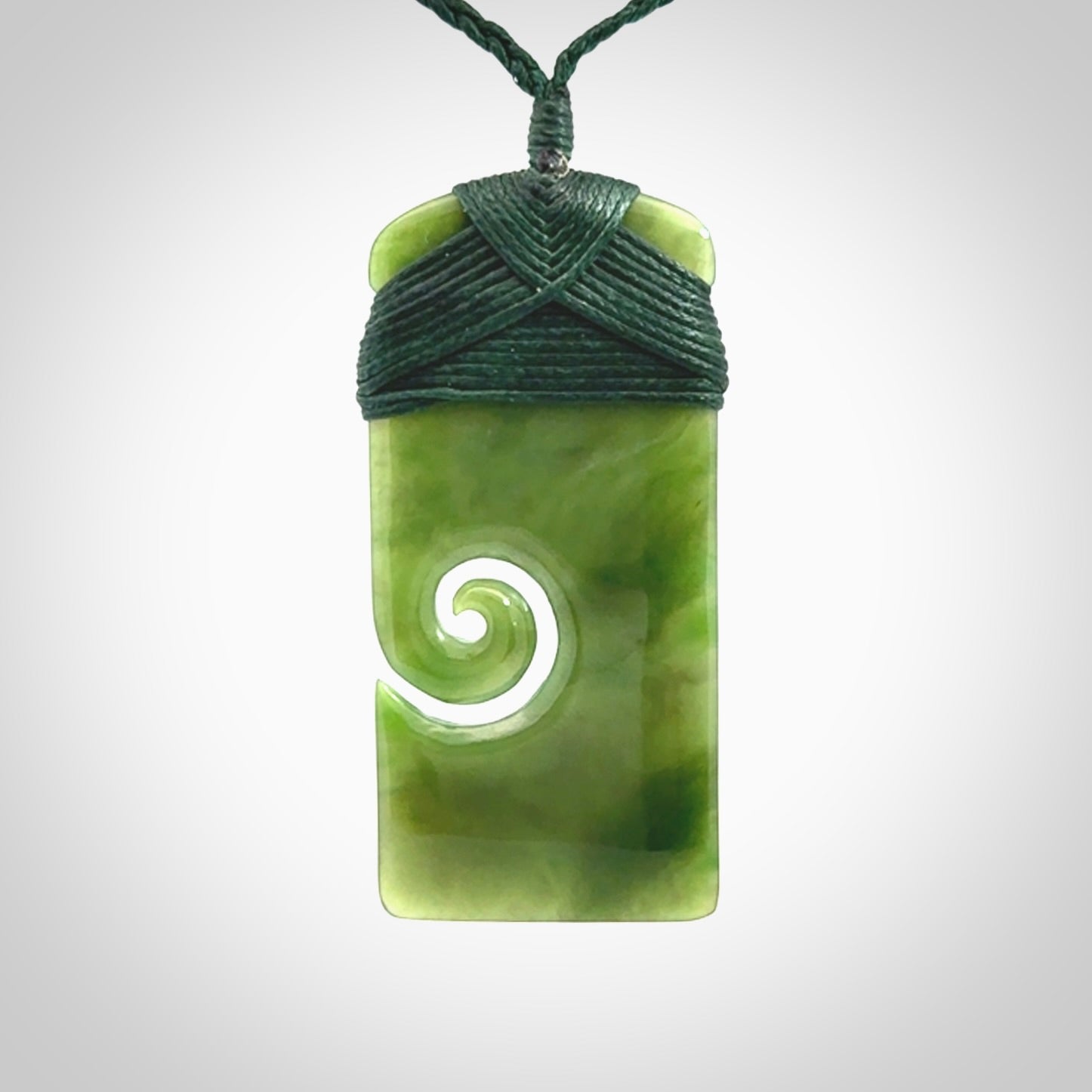 British Coloumbian jade toki koru pendant. Hand carved in New Zealand. Hand made British Coloumbian Jade jewellery. Provided with an adjustable cord and packaged in a woven kete pouch.