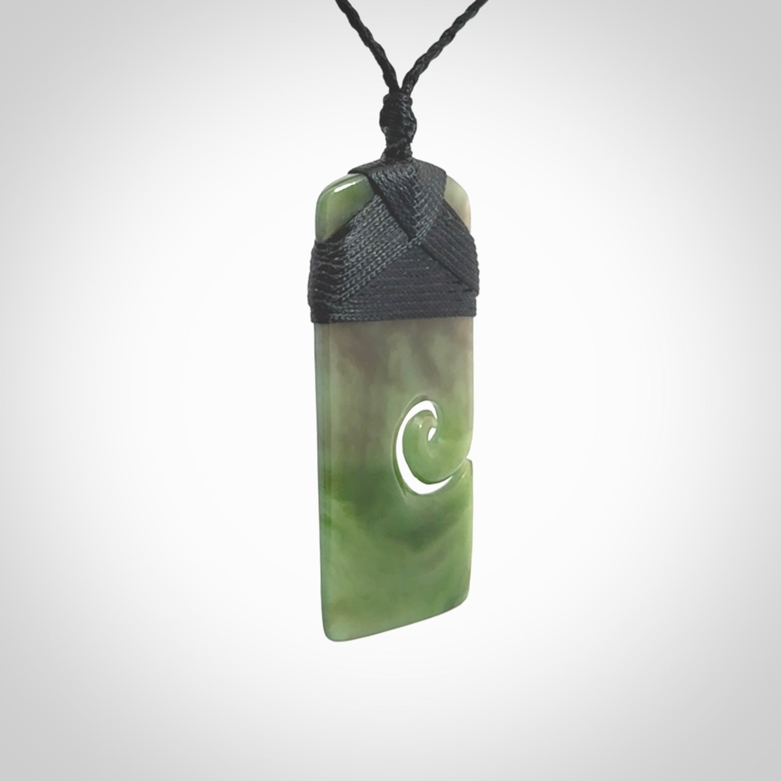 British Coloumbian jade toki koru pendant. Hand carved in New Zealand. Hand made British Coloumbian Jade jewellery. Provided with an adjustable cord and packaged in a woven kete pouch.
