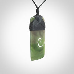 British Coloumbian jade toki koru pendant. Hand carved in New Zealand. Hand made British Coloumbian Jade jewellery. Provided with an adjustable cord and packaged in a woven kete pouch.