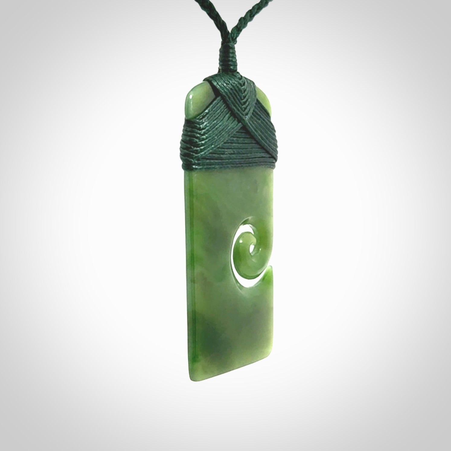 British Coloumbian jade toki koru pendant. Hand carved in New Zealand. Hand made British Coloumbian Jade jewellery. Provided with an adjustable cord and packaged in a woven kete pouch.