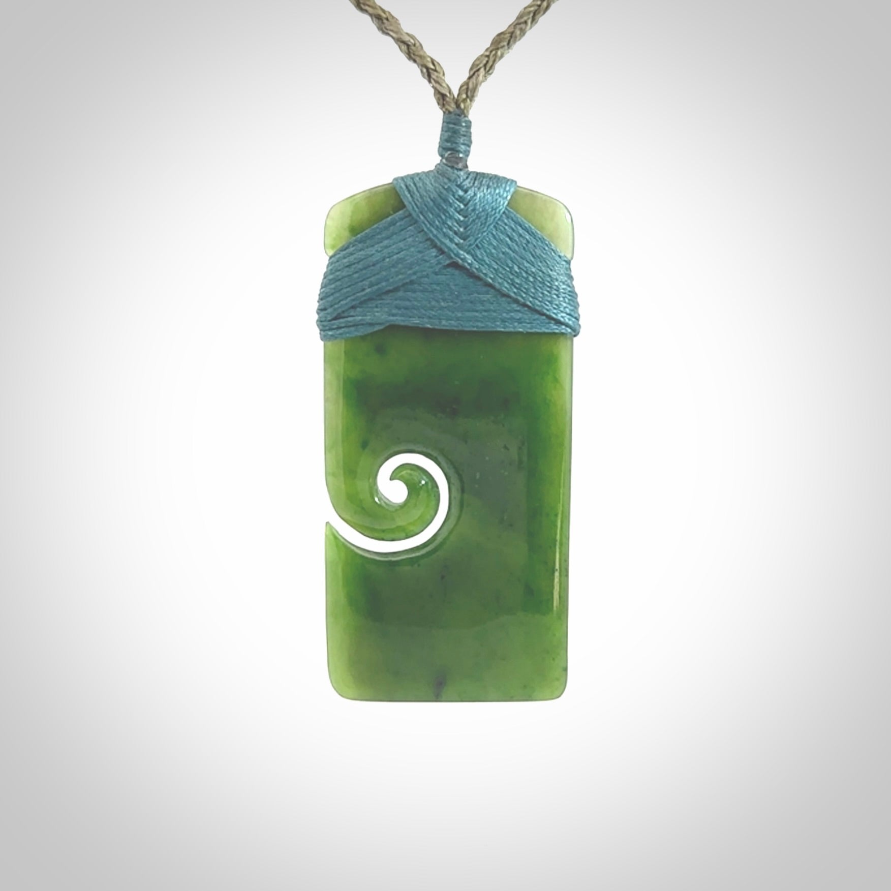 British Coloumbian jade toki koru pendant. Hand carved in New Zealand. Hand made British Coloumbian Jade jewellery. Provided with an adjustable cord and packaged in a woven kete pouch.