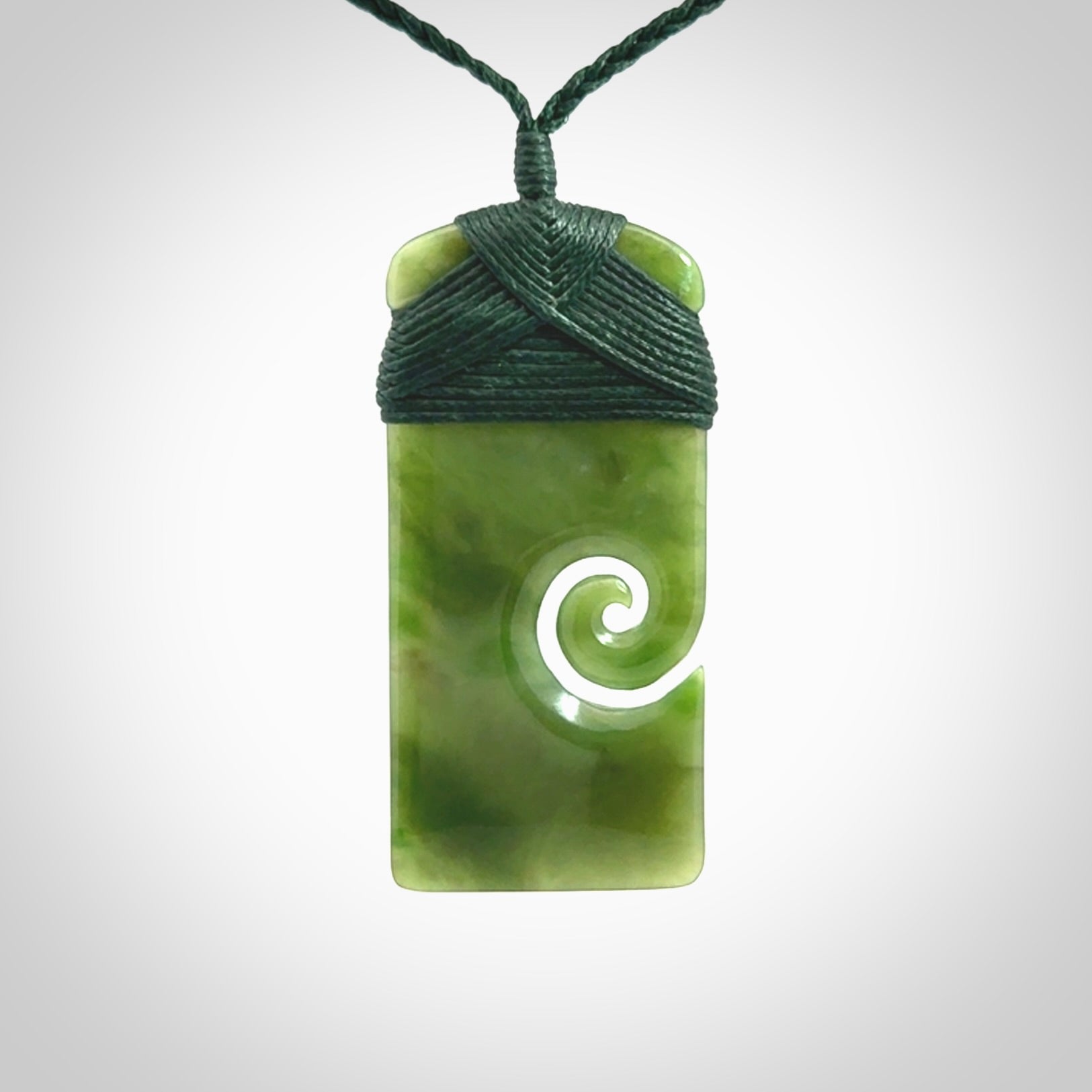 British Coloumbian jade toki koru pendant. Hand carved in New Zealand. Hand made British Coloumbian Jade jewellery. Provided with an adjustable cord and packaged in a woven kete pouch.
