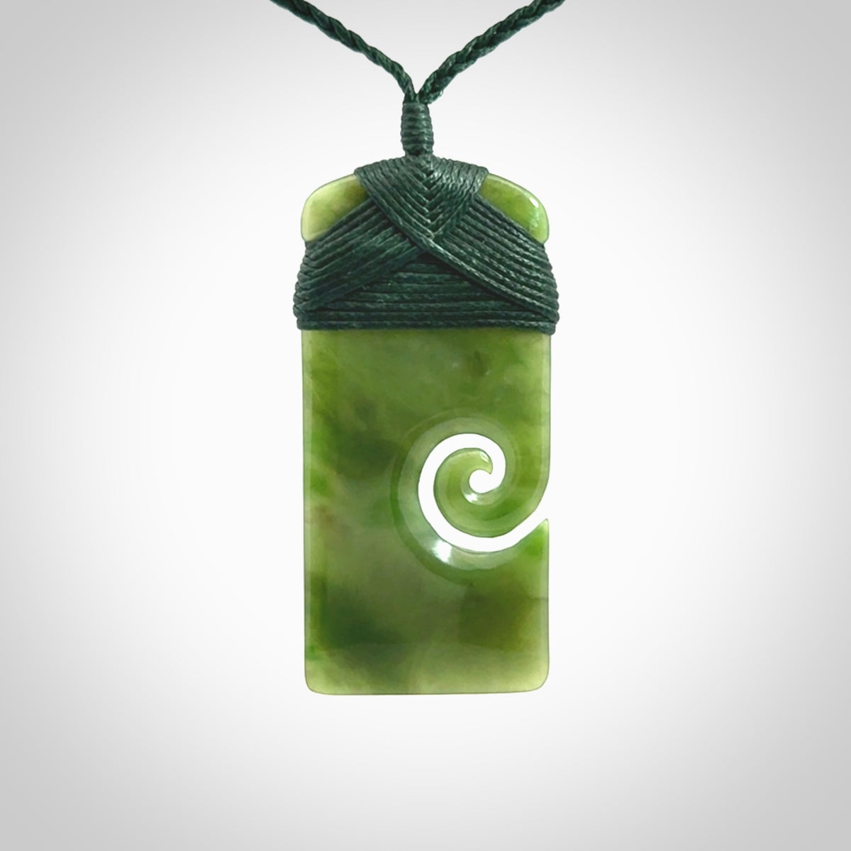 British Coloumbian jade toki koru pendant. Hand carved in New Zealand. Hand made British Coloumbian Jade jewellery. Provided with an adjustable cord and packaged in a woven kete pouch.