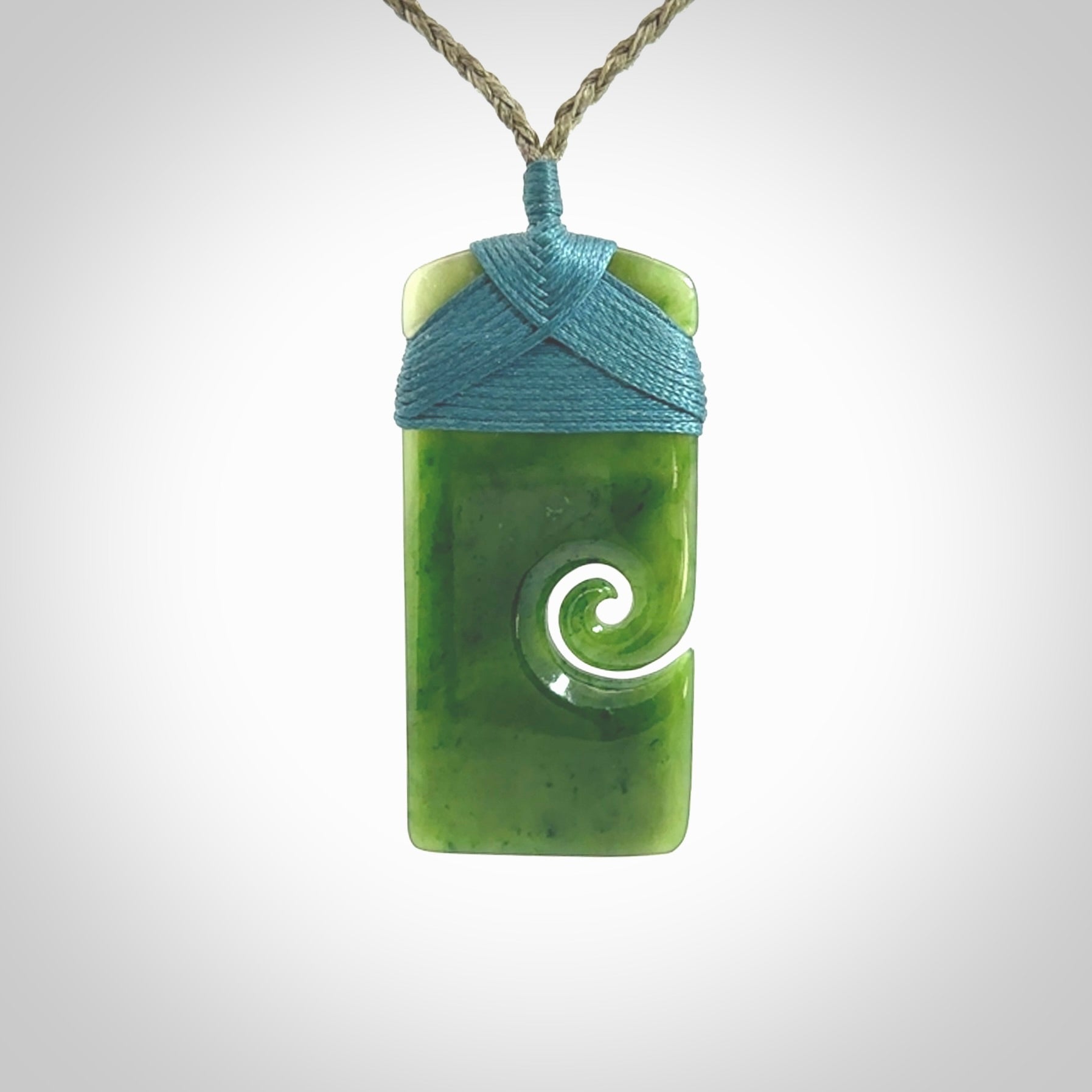 British Coloumbian jade toki koru pendant. Hand carved in New Zealand. Hand made British Coloumbian Jade jewellery. Provided with an adjustable cord and packaged in a woven kete pouch.