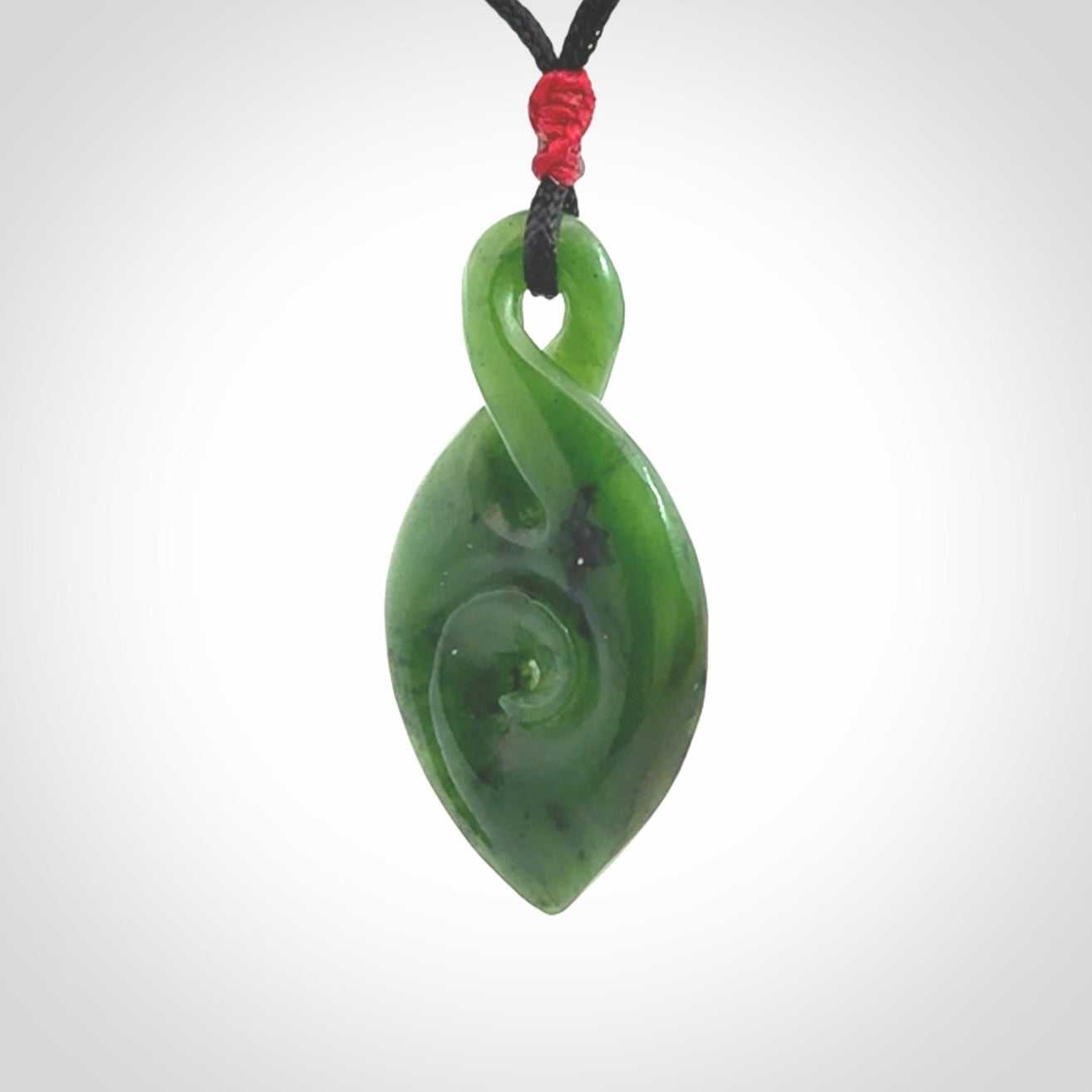 Ross Crump twist with koru pendant. Hand carved from rare New Zealand jade this is a beautiful pounamu pendant. The cord is length adjustable. It has a little spiral floret at the top of the pendant.