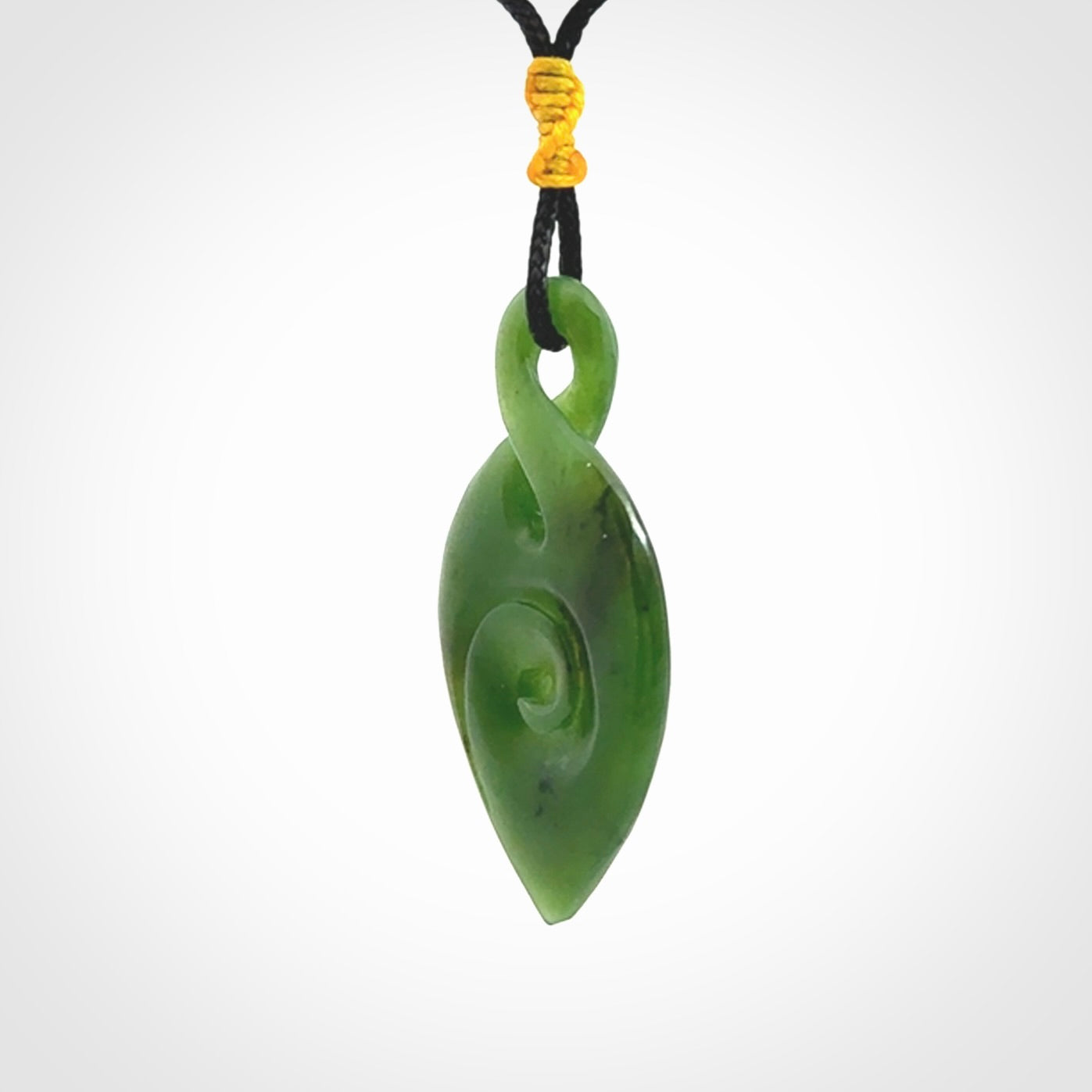 Ross Crump twist with koru pendant. Hand carved from rare New Zealand jade this is a beautiful pounamu pendant. The cord is a black colour and is length adjustable. It has a little spiral floret popper at the top of the pendant. It is a delicate and very beautiful greenstone pendant. For sale online by NZ Pacific.