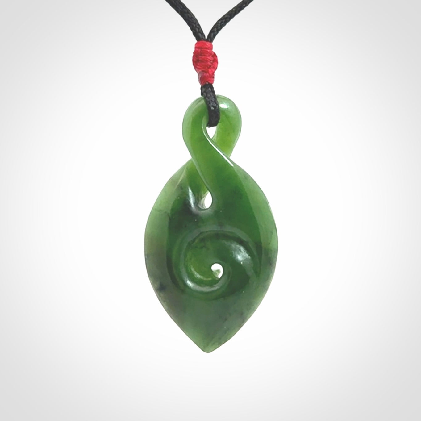 Ross Crump twist with koru pendant. Hand carved from rare New Zealand jade this is a beautiful pounamu pendant. The cord is length adjustable. It has a little spiral floret at the top of the pendant.