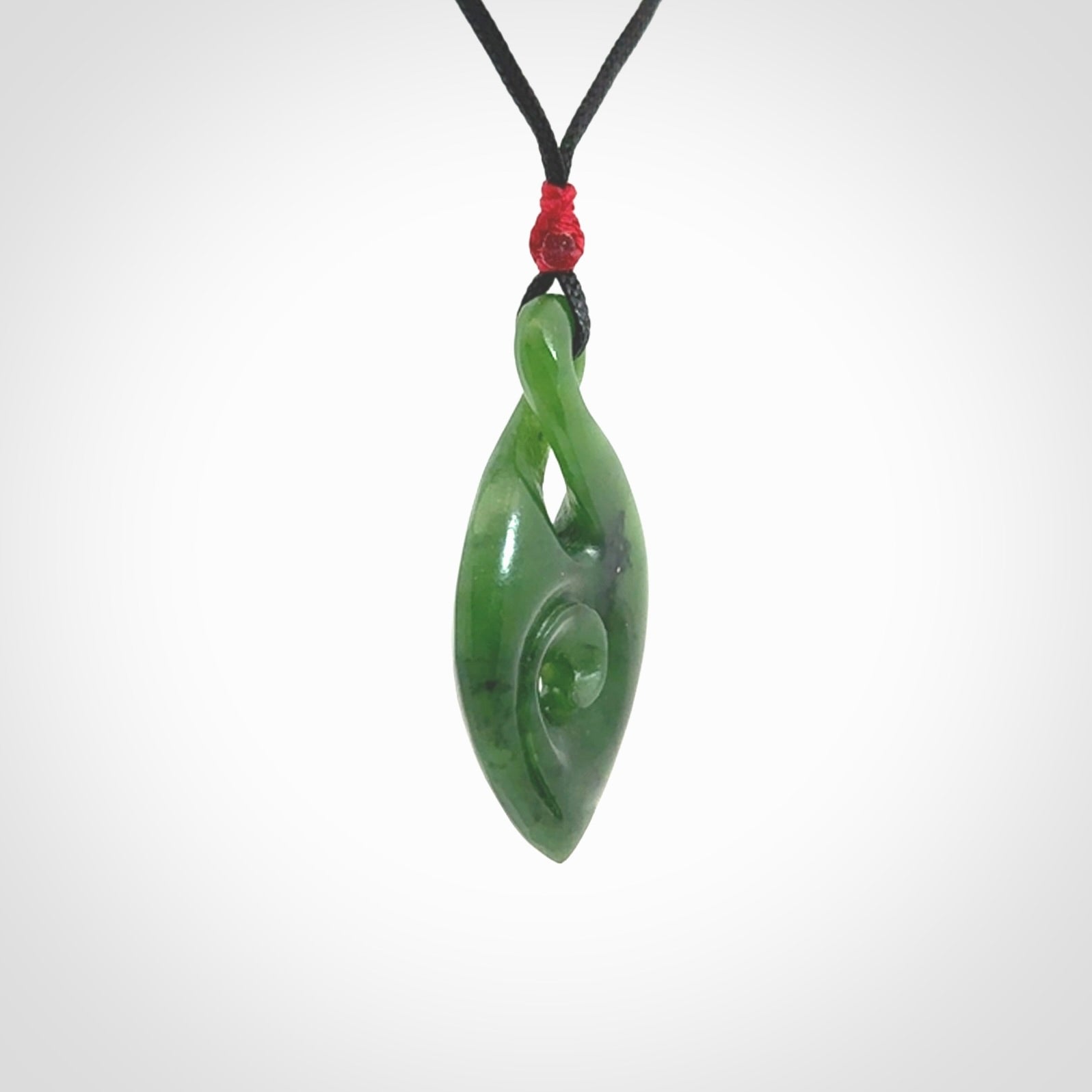 Ross Crump twist with koru pendant. Hand carved from rare New Zealand jade this is a beautiful pounamu pendant. The cord is length adjustable. It has a little spiral floret at the top of the pendant.