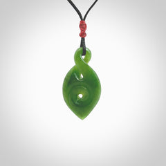 Ross Crump twist with koru pendant. Hand carved from rare New Zealand jade this is a beautiful pounamu pendant. The cord is hand plaited and is length adjustable. It has a little spiral floret popper at the top of the pendant. It is a delicate and very beautiful greenstone pendant. For sale online by NZ Pacific.