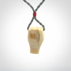 Hand carved fist pendant symbolising strength and hope. Carved by NZ Pacific from ancient woolly mammoth tusk.