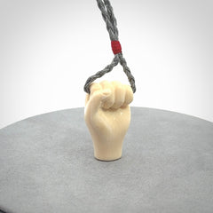 Hand carved fist pendant symbolising strength and hope. Carved by NZ Pacific from ancient woolly mammoth tusk.