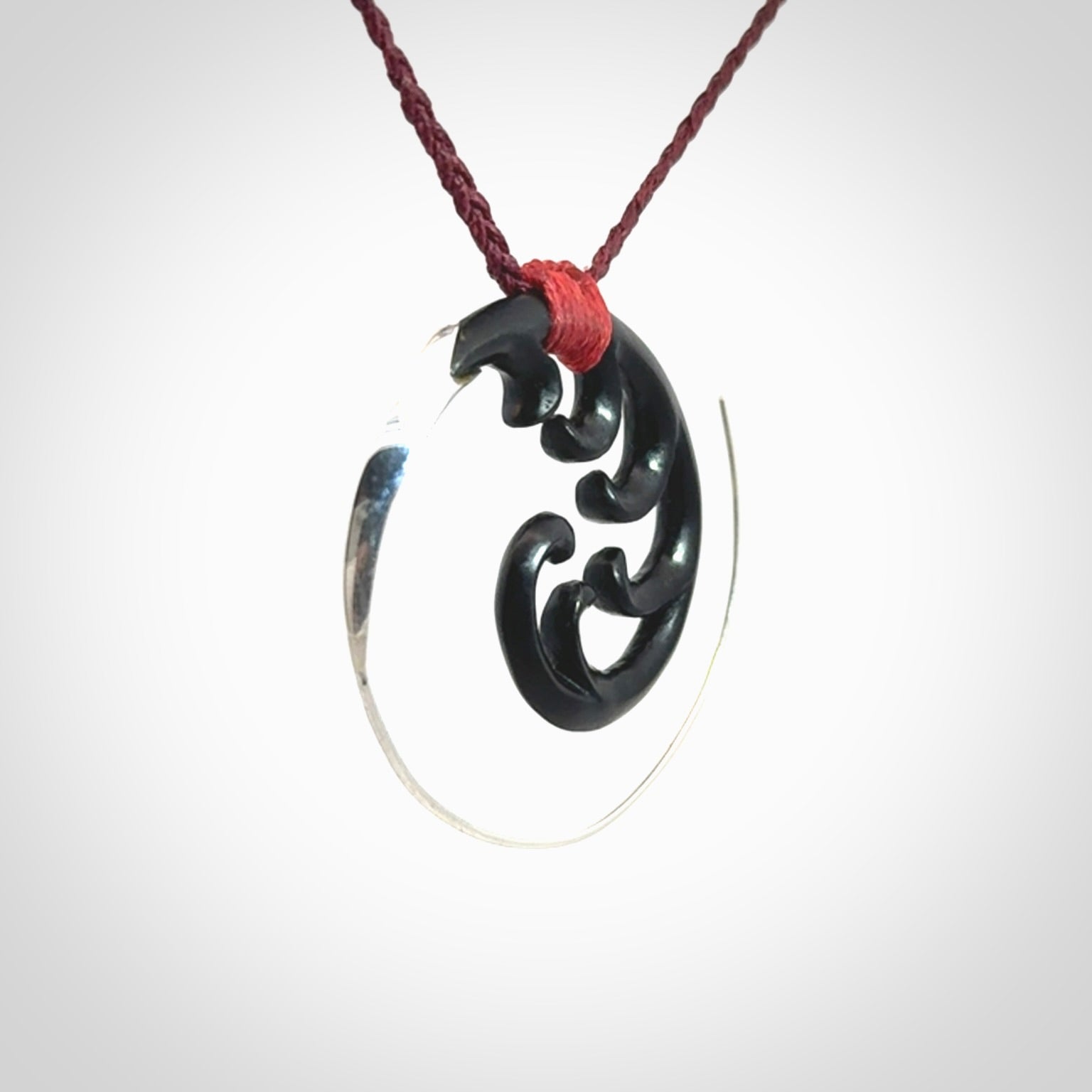 Hand carved pendant made from black jade with sterling silver. NZ Pacific contemporary Koru pendant for sale online.