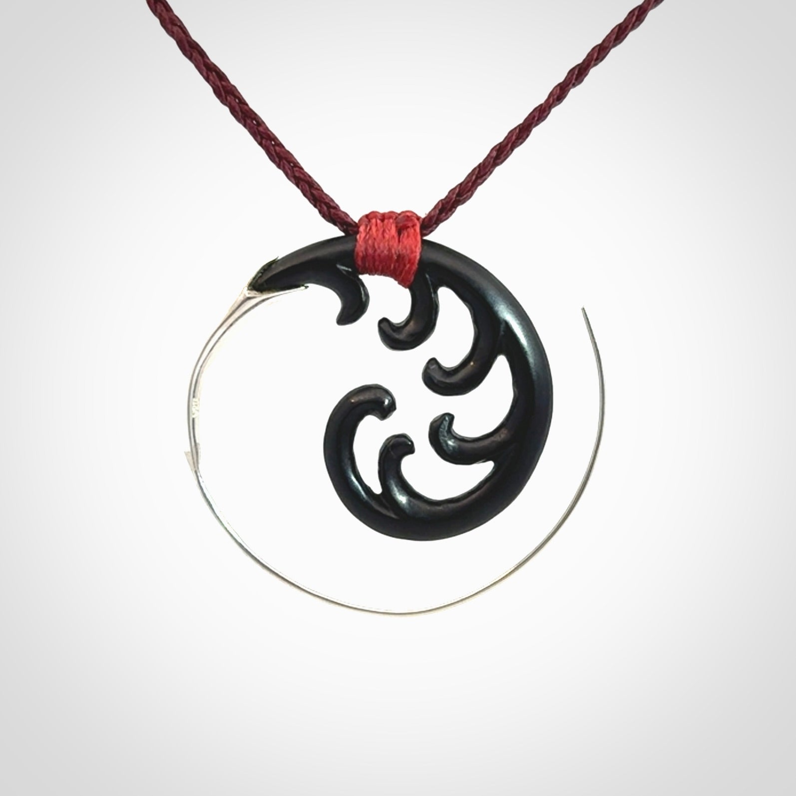 Hand carved pendant made from black jade with sterling silver. NZ Pacific contemporary Koru pendant for sale online.