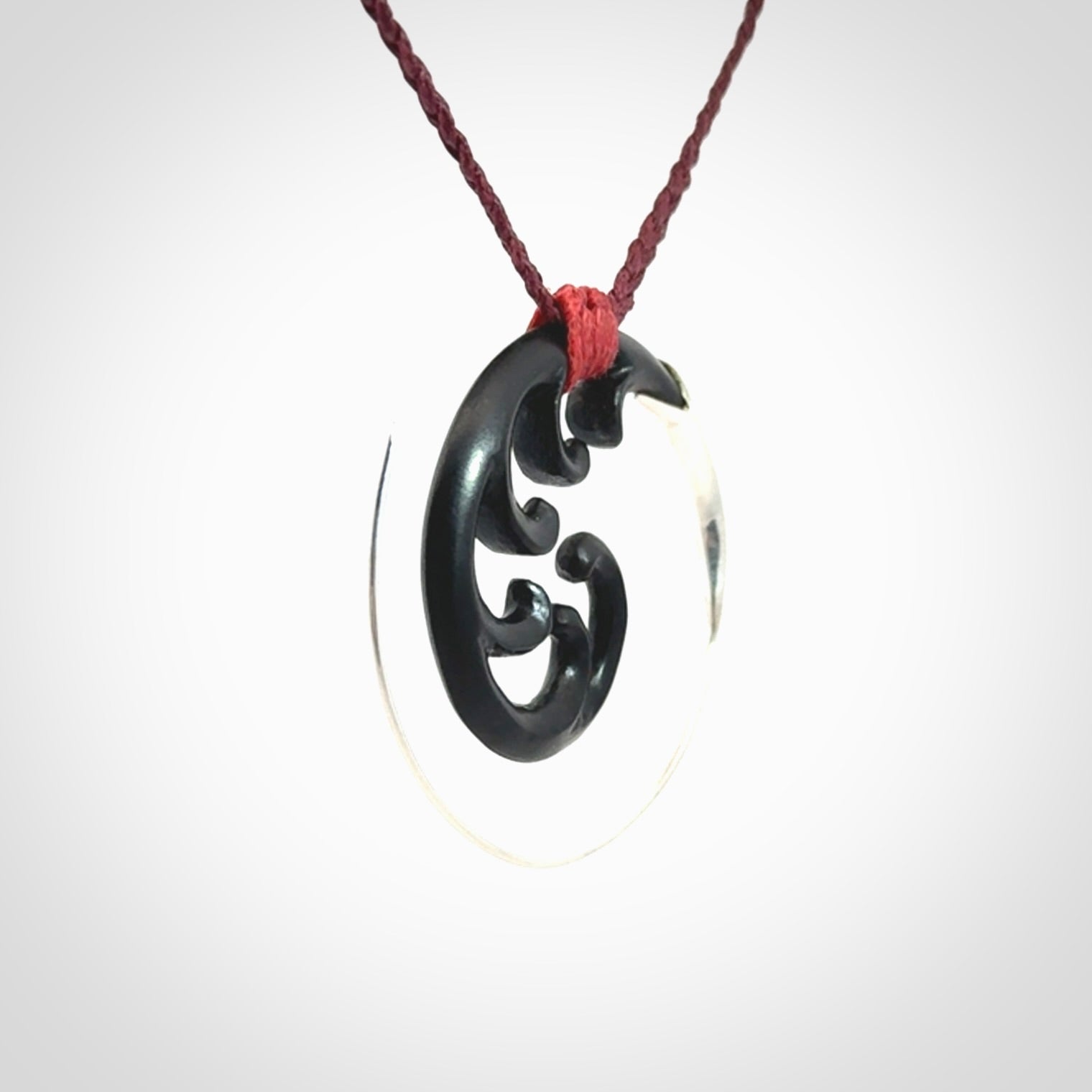 Hand carved pendant made from black jade with sterling silver. NZ Pacific contemporary Koru pendant for sale online.