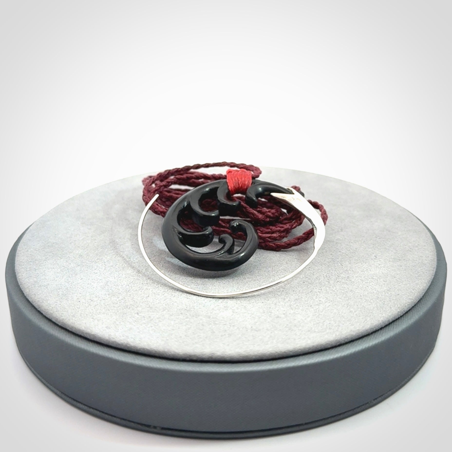 Hand carved pendant made from black jade with sterling silver. NZ Pacific contemporary Koru pendant for sale online.