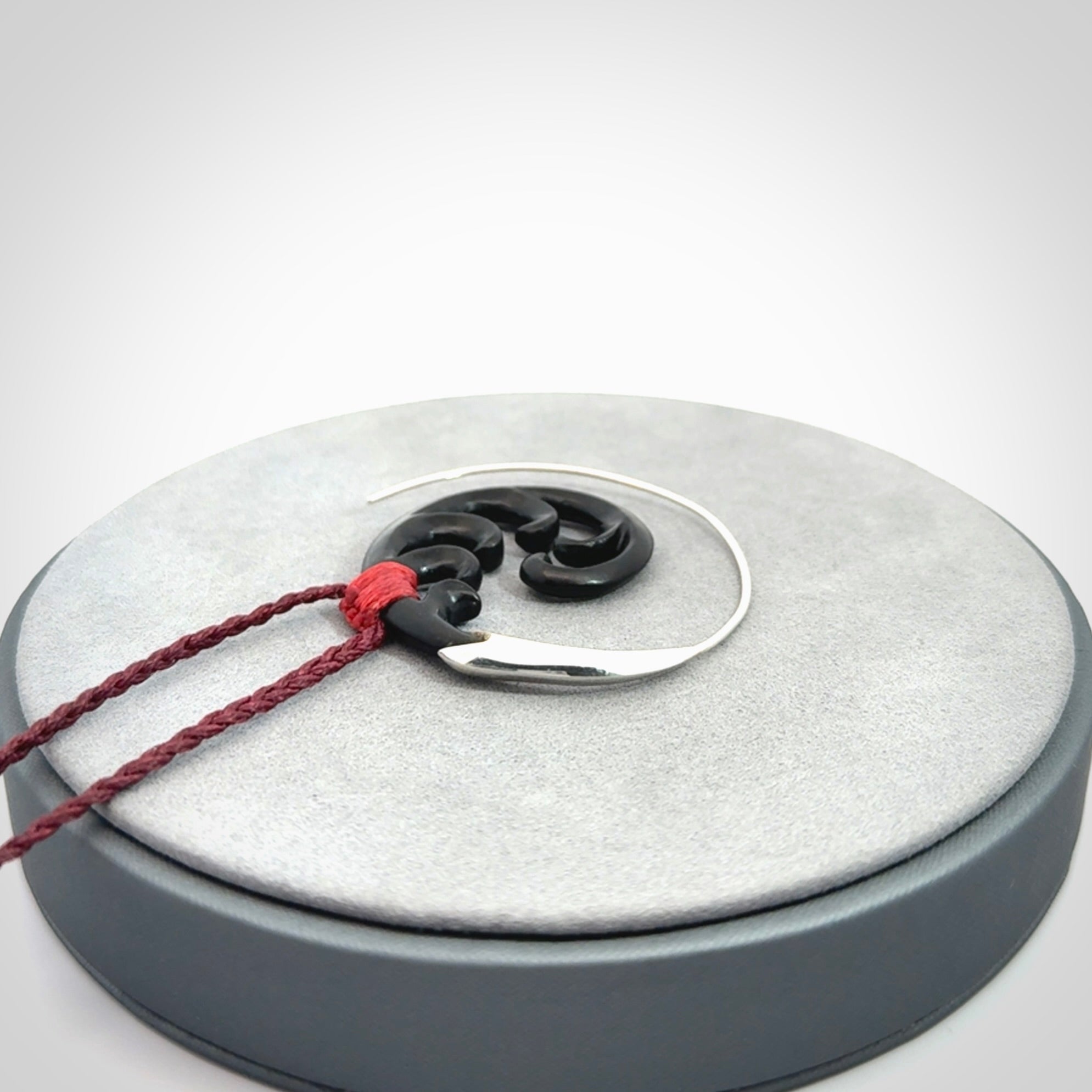 Hand carved pendant made from black jade with sterling silver. NZ Pacific contemporary Koru pendant for sale online.
