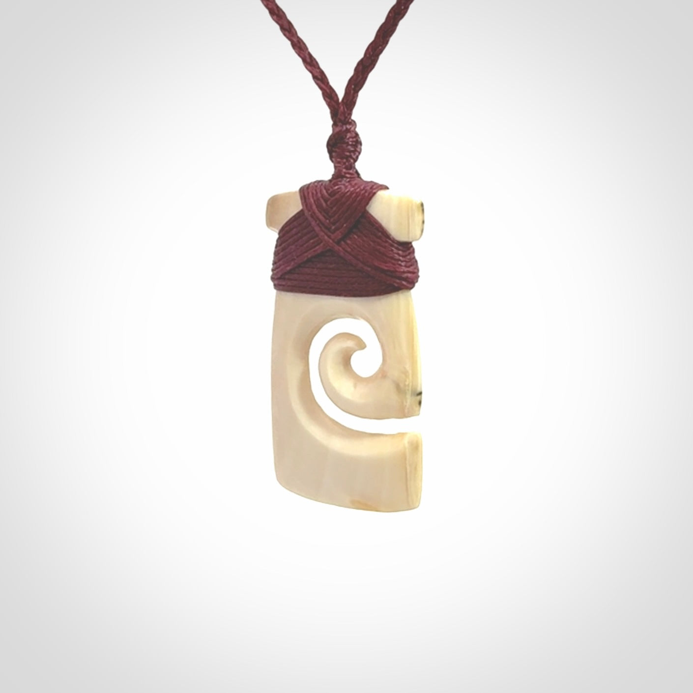 Hand carved Woolly Mammoth Tusk toki with koru pendant. Toki with koru necklace carved from ancient woolly mammoth tusk. Provided with adjustable cord and packaged in a woven kete pouch.
