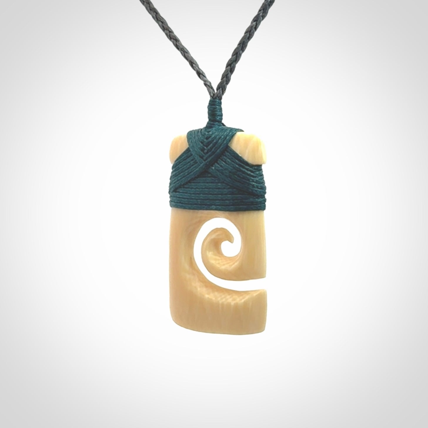 Hand carved Woolly Mammoth Tusk toki with koru pendant. Toki with koru necklace carved from ancient woolly mammoth tusk. Provided with adjustable cord and packaged in a woven kete pouch.