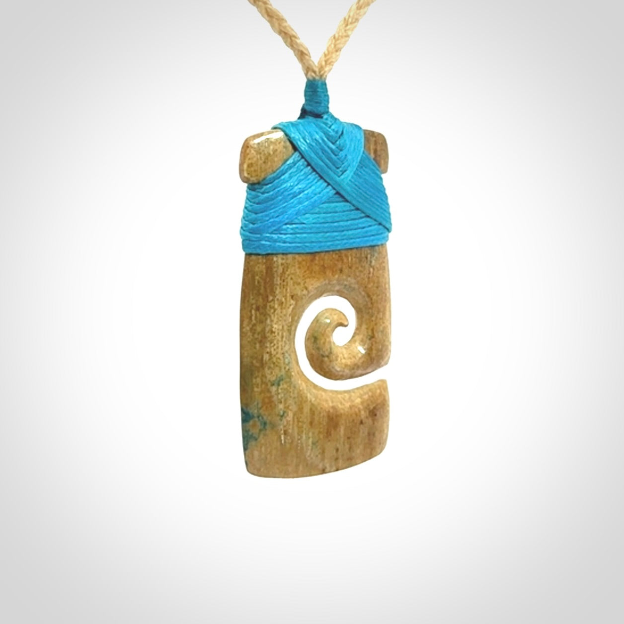 Hand carved Woolly Mammoth Tusk toki with koru pendant. Toki with koru necklace carved from ancient woolly mammoth tusk. Provided with adjustable cord and packaged in a woven kete pouch.