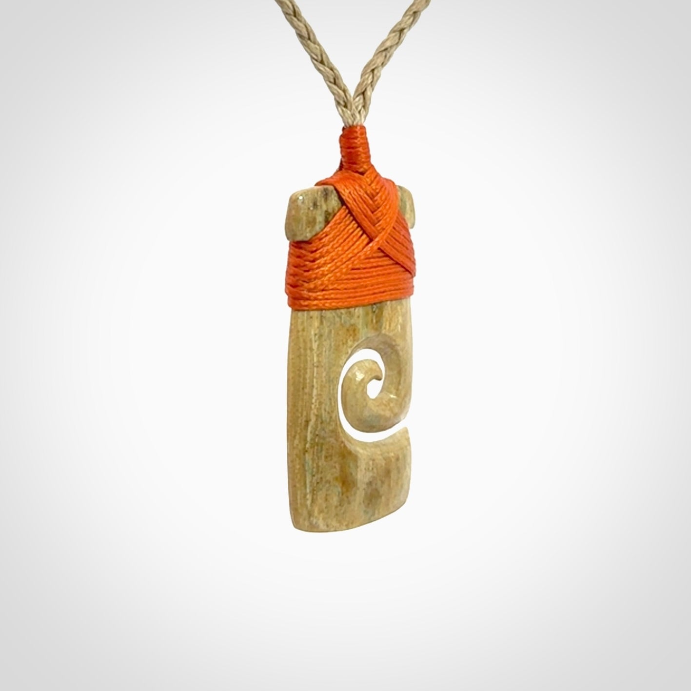 Hand carved Woolly Mammoth Tusk toki with koru pendant. Toki with koru necklace carved from ancient woolly mammoth tusk. Provided with adjustable cord and packaged in a woven kete pouch.