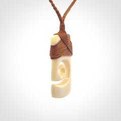Hand carved Woolly Mammoth Tusk toki with koru pendant. Toki with koru necklace carved from ancient woolly mammoth tusk. Provided with adjustable cord and packaged in a woven kete pouch.