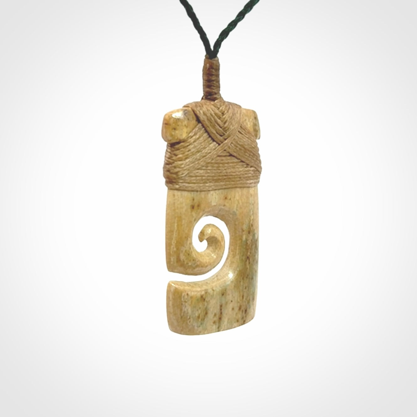 Hand carved Woolly Mammoth Tusk toki with koru pendant. Toki with koru necklace carved from ancient woolly mammoth tusk. Provided with adjustable cord and packaged in a woven kete pouch.