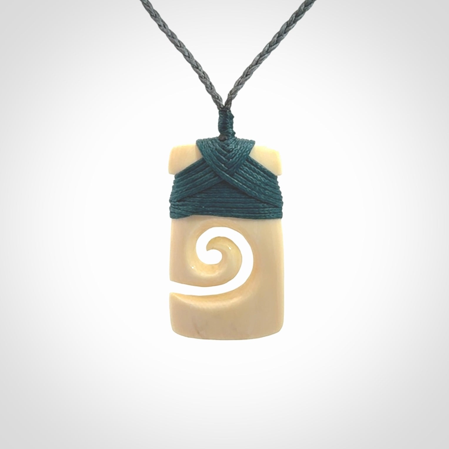 Hand carved Woolly Mammoth Tusk toki with koru pendant. Toki with koru necklace carved from ancient woolly mammoth tusk. Provided with adjustable cord and packaged in a woven kete pouch.