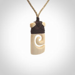 Hand carved Woolly Mammoth Tusk toki with koru pendant. Toki with koru necklace carved from ancient woolly mammoth tusk. Provided with adjustable cord and packaged in a woven kete pouch.