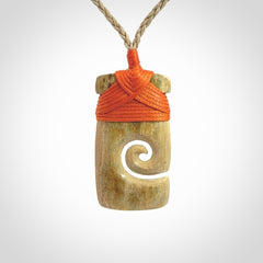 Hand carved Woolly Mammoth Tusk toki with koru pendant. Toki with koru necklace carved from ancient woolly mammoth tusk. Provided with adjustable cord and packaged in a woven kete pouch.