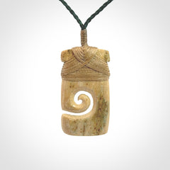 Hand carved Woolly Mammoth Tusk toki with koru pendant. Toki with koru necklace carved from ancient woolly mammoth tusk. Provided with adjustable cord and packaged in a woven kete pouch.
