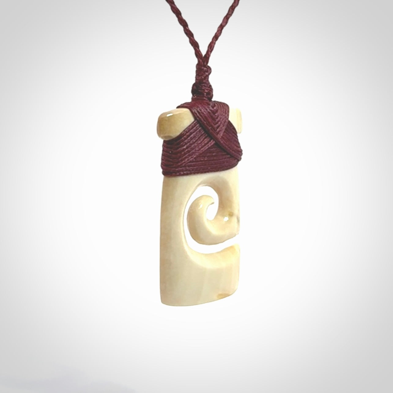 Hand carved Woolly Mammoth Tusk toki with koru pendant. Toki with koru necklace carved from ancient woolly mammoth tusk. Provided with adjustable cord and packaged in a woven kete pouch.