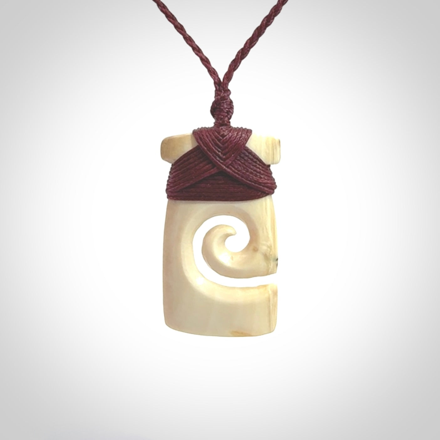 Hand carved Woolly Mammoth Tusk toki with koru pendant. Toki with koru necklace carved from ancient woolly mammoth tusk. Provided with adjustable cord and packaged in a woven kete pouch.