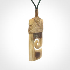 Hand carved Woolly Mammoth Tusk toki with koru pendant. Toki with koru necklace carved from ancient woolly mammoth tusk. Provided with adjustable cord and packaged in a woven kete pouch.