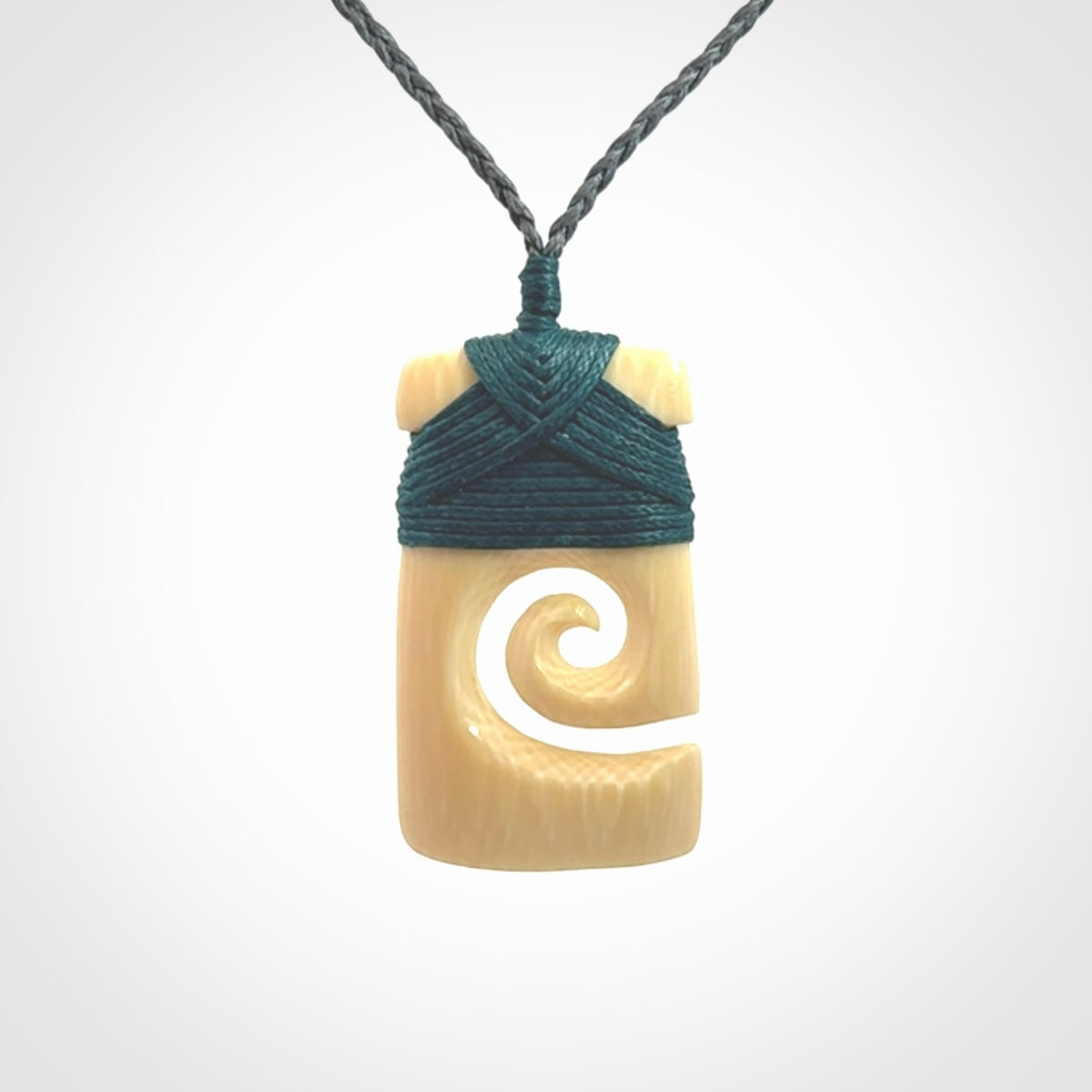 Hand carved Woolly Mammoth Tusk toki with koru pendant. Toki with koru necklace carved from ancient woolly mammoth tusk. Provided with adjustable cord and packaged in a woven kete pouch.
