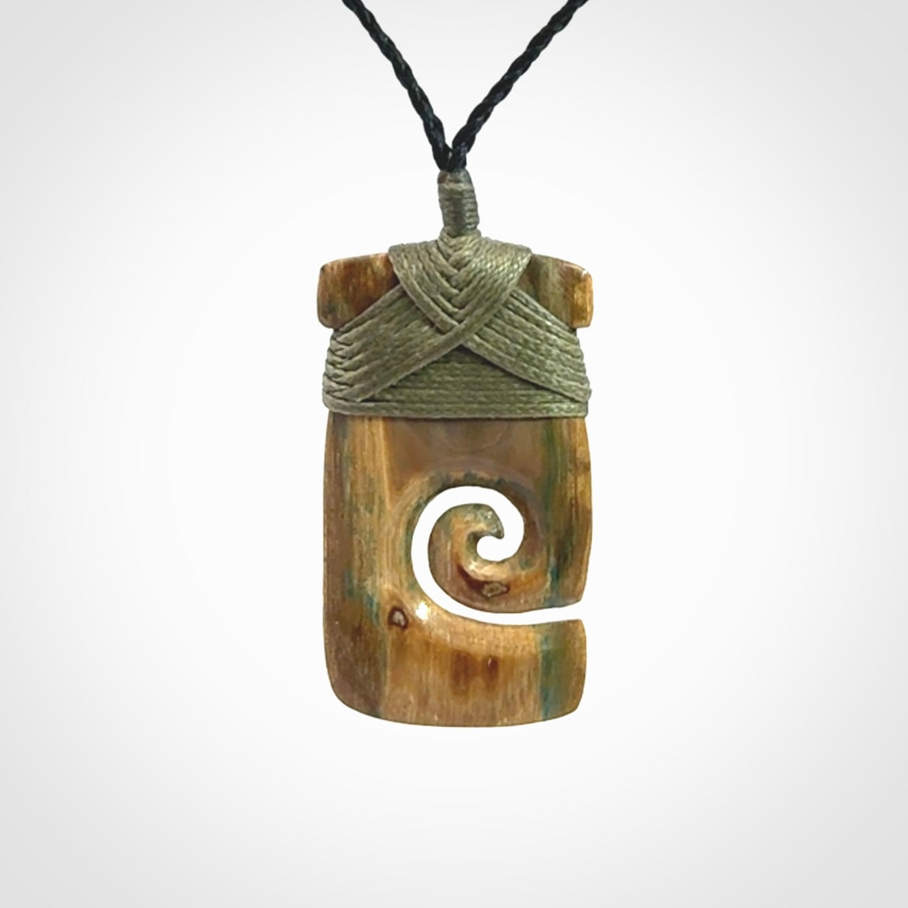 Hand carved Woolly Mammoth Tusk toki with koru pendant. Toki with koru necklace carved from ancient woolly mammoth tusk. Provided with adjustable cord and packaged in a woven kete pouch.