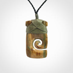 Hand carved Woolly Mammoth Tusk toki with koru pendant. Toki with koru necklace carved from ancient woolly mammoth tusk. Provided with adjustable cord and packaged in a woven kete pouch.