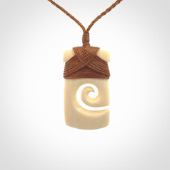 Hand carved Woolly Mammoth Tusk toki with koru pendant. Toki with koru necklace carved from ancient woolly mammoth tusk. Provided with adjustable cord and packaged in a woven kete pouch.