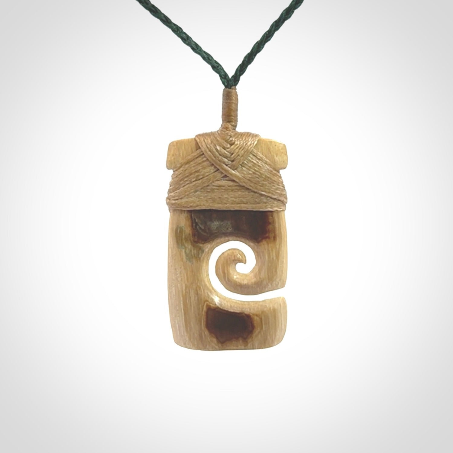 Hand carved Woolly Mammoth Tusk toki with koru pendant. Toki with koru necklace carved from ancient woolly mammoth tusk. Provided with adjustable cord and packaged in a woven kete pouch.