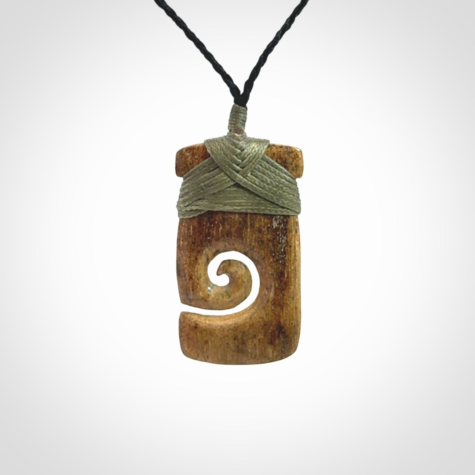 Hand carved Woolly Mammoth Tusk toki with koru pendant. Toki with koru necklace carved from ancient woolly mammoth tusk. Provided with adjustable cord and packaged in a woven kete pouch.