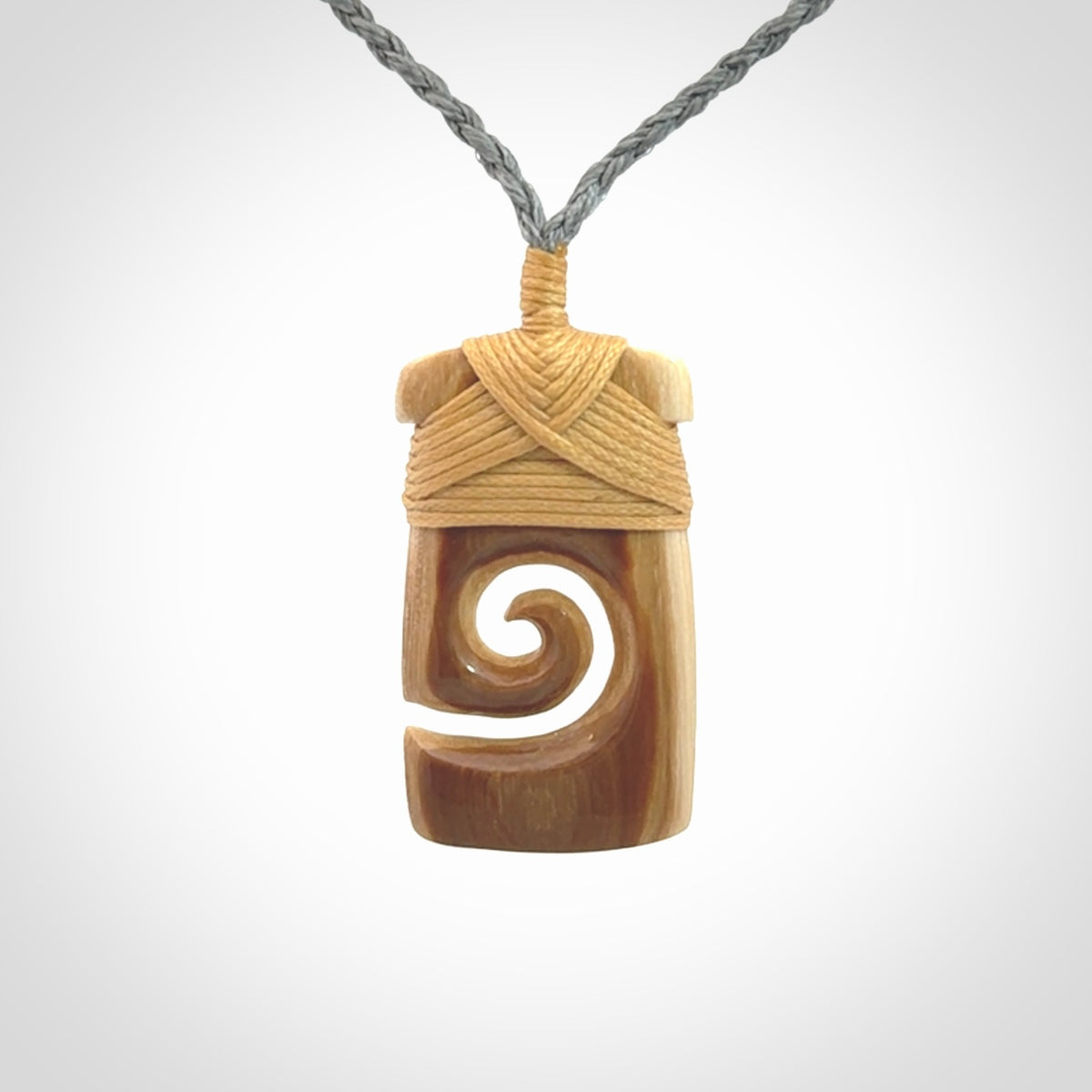 Hand carved Woolly Mammoth Tusk toki with koru pendant. Toki with koru necklace carved from ancient woolly mammoth tusk. Provided with adjustable cord and packaged in a woven kete pouch.