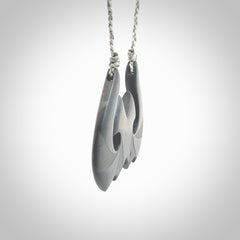 A hand carved large New Zealand Argillite double Hook, Matau, necklace. The cord is a black colour and is adjustable in length. A large sized hand made double hook necklace by New Zealand artist Rueben Tipene. One off work of art to wear.