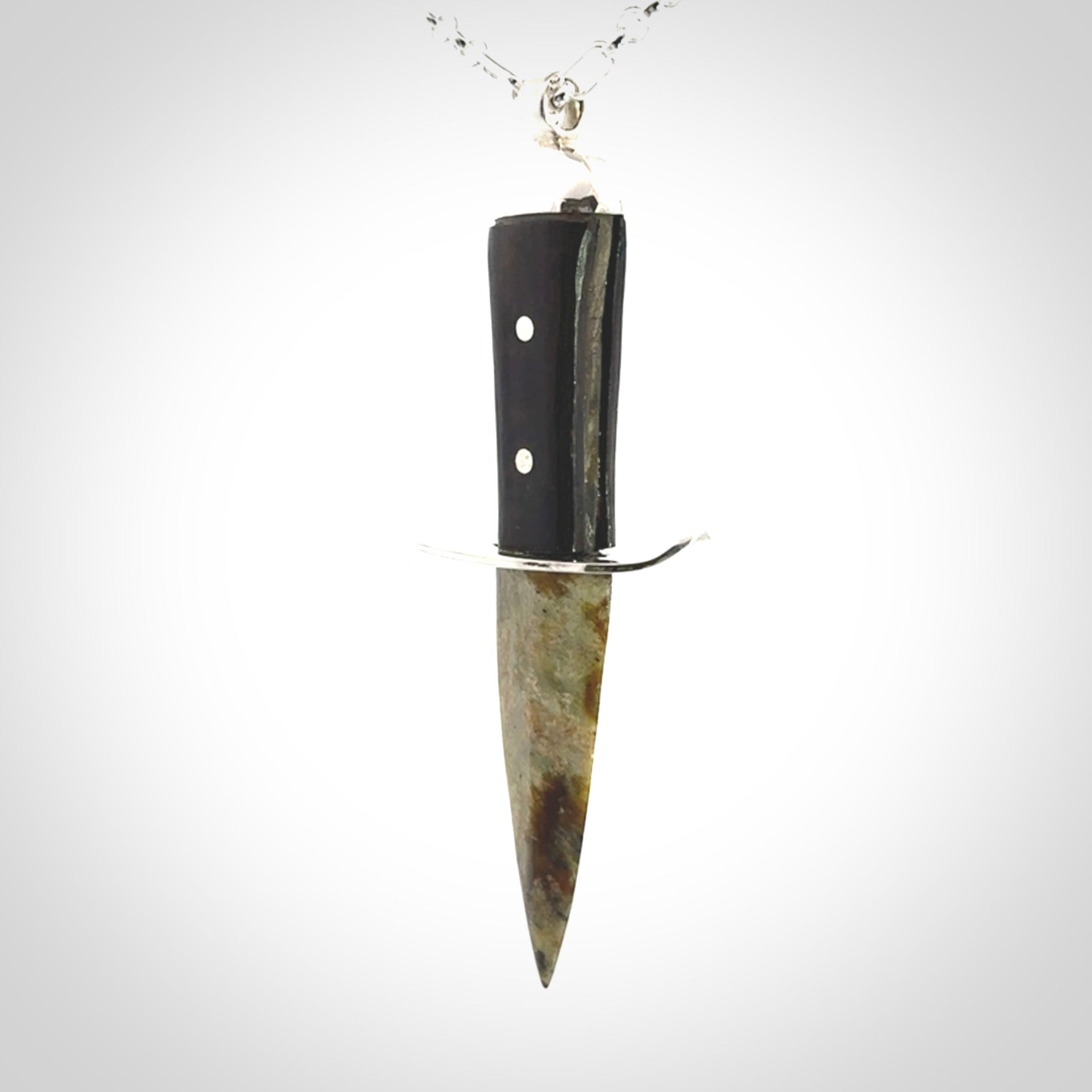 A striking hand carved knife pendant. These are carved with a green jade head and a hardwood handle. The necklace is sterling silver. We ship these worldwide with express courier.