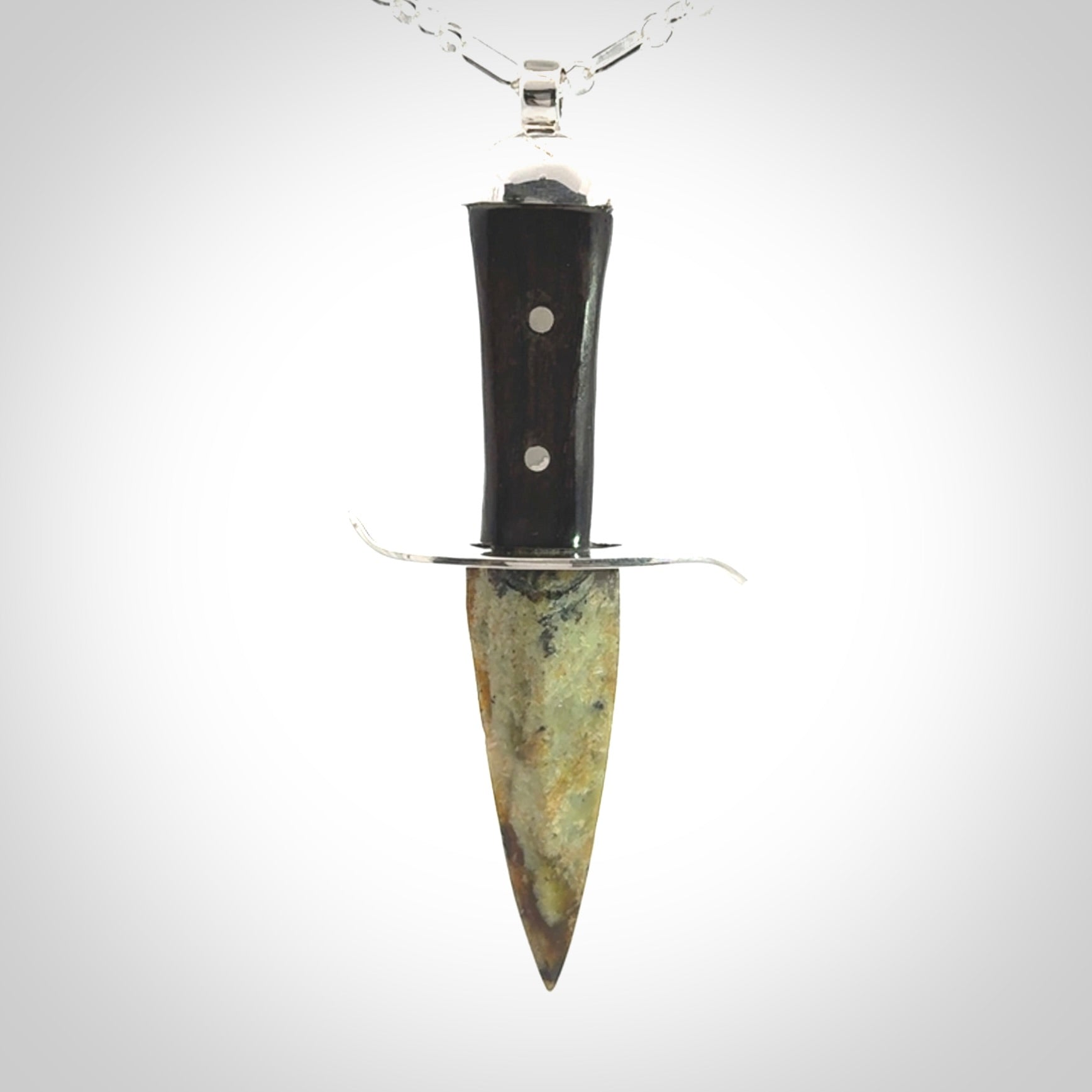 A striking hand carved knife pendant. These are carved with a green jade head and a hardwood handle. The necklace is sterling silver. We ship these worldwide with express courier.