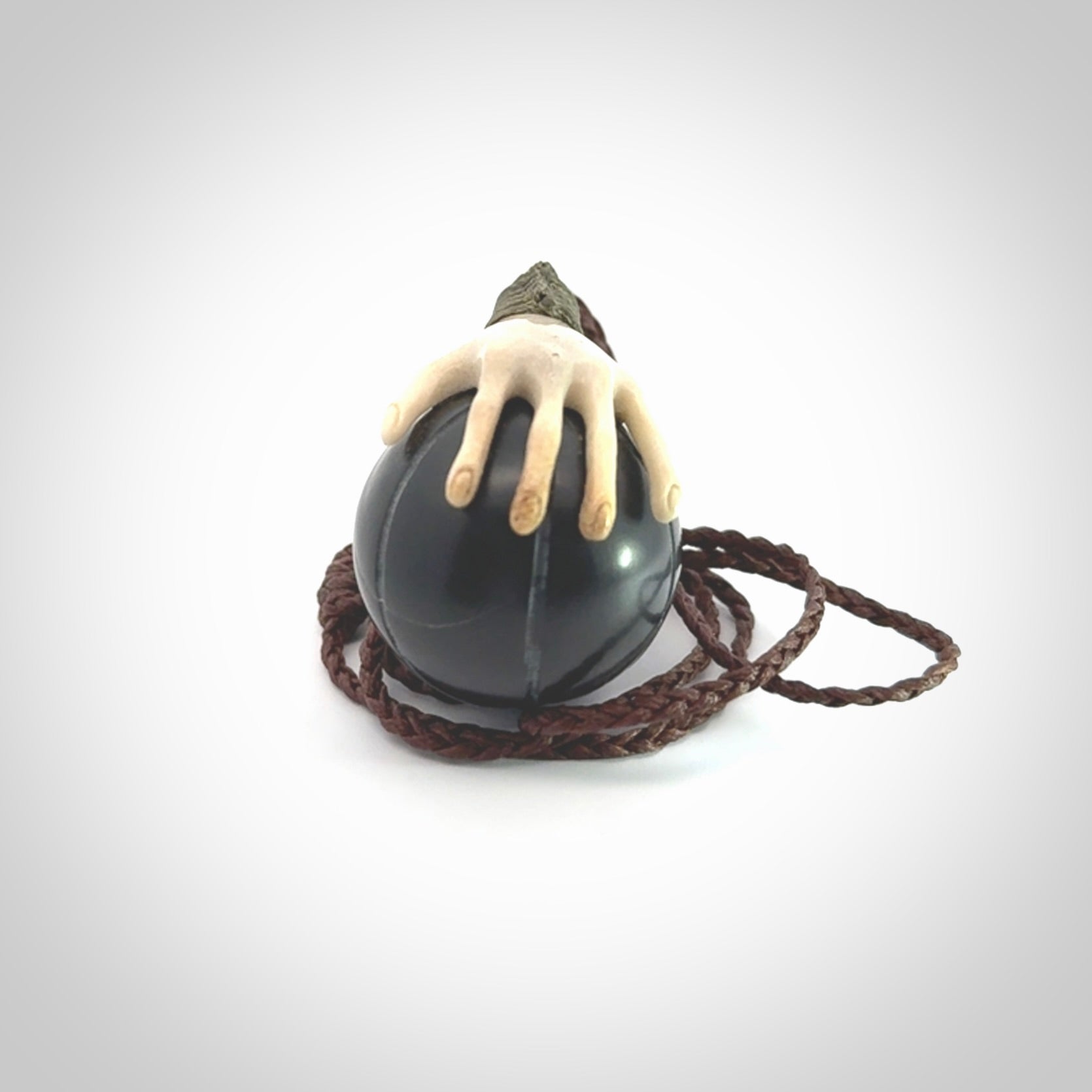 This is a very cool pendant that we've had carved for all you Basketball fans. The DUNK is a pendant with a deer antler hand holding a black jade basketball. We provide this on an adjustable cord, and we ship worldwide. A very cool pendant, different, edgy and very wearable.