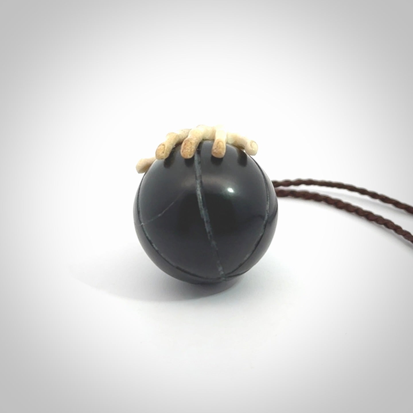 This is a very cool pendant that we've had carved for all you Basketball fans. The DUNK is a pendant with a deer antler hand holding a black jade basketball. We provide this on an adjustable cord, and we ship worldwide. A very cool pendant, different, edgy and very wearable.