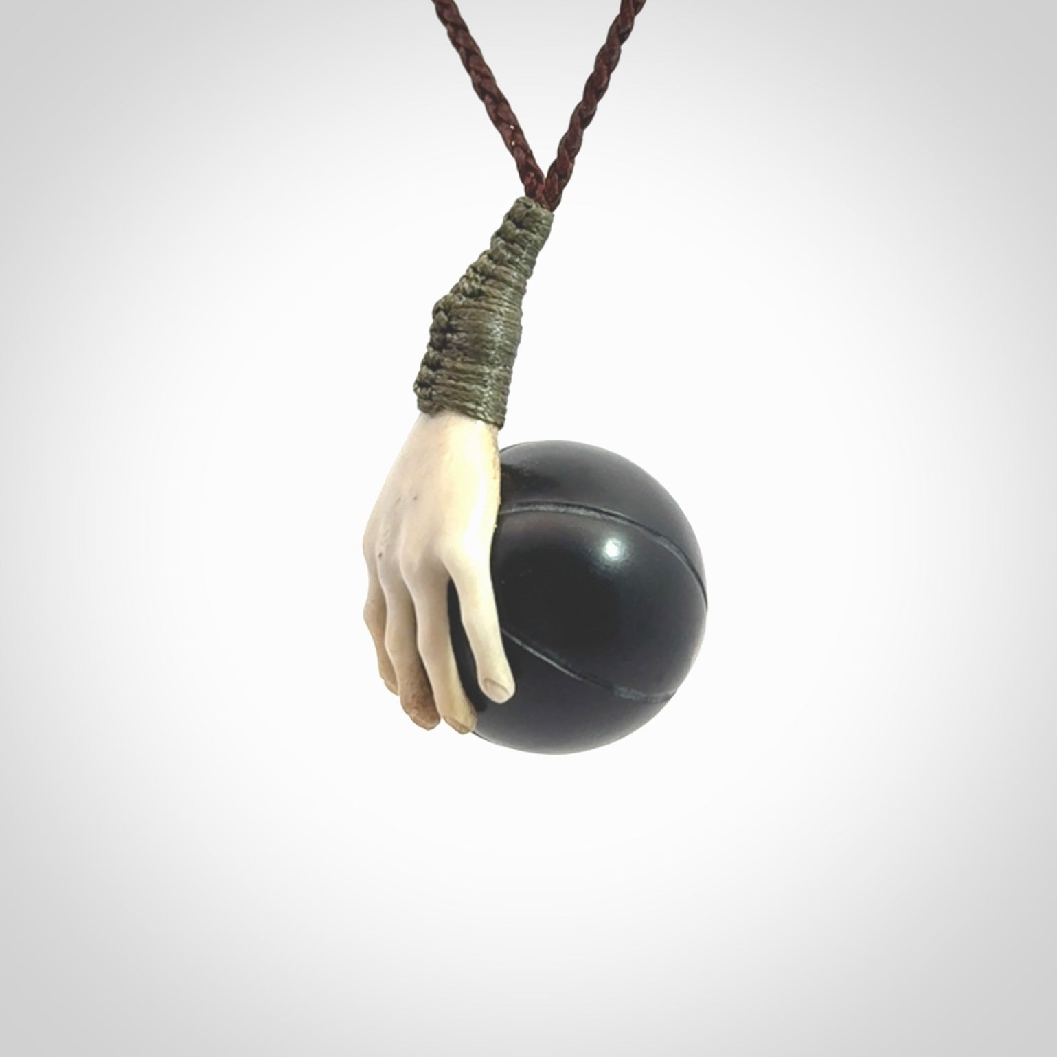 This is a very cool pendant that we've had carved for all you Basketball fans. The DUNK is a pendant with a deer antler hand holding a black jade basketball. We provide this on an adjustable cord, and we ship worldwide. A very cool pendant, different, edgy and very wearable.