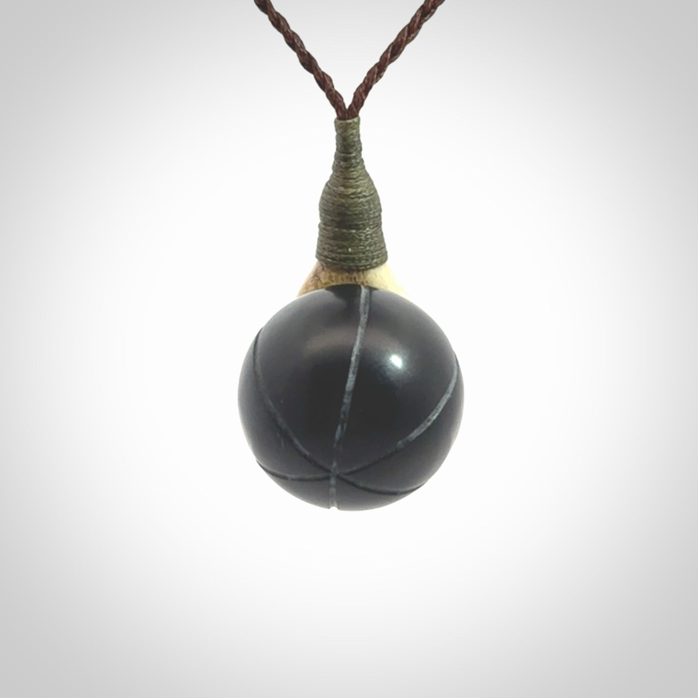This is a very cool pendant that we've had carved for all you Basketball fans. The DUNK is a pendant with a deer antler hand holding a black jade basketball. We provide this on an adjustable cord, and we ship worldwide. A very cool pendant, different, edgy and very wearable.