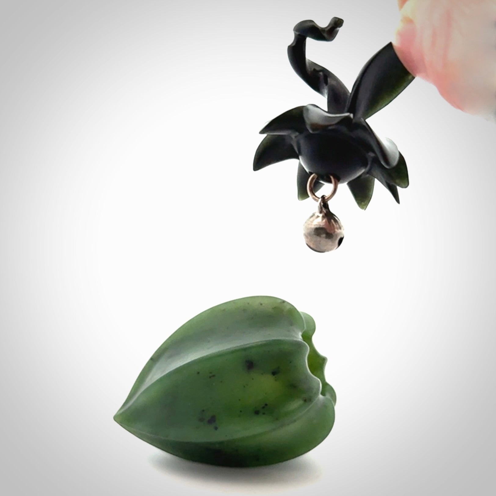 Hand carved Gooseberry sculpture crafted in Black Jade, British Columbian Jade with Basalt stone stand. One only Gooseberry sculpture with lid that encloses a bell.