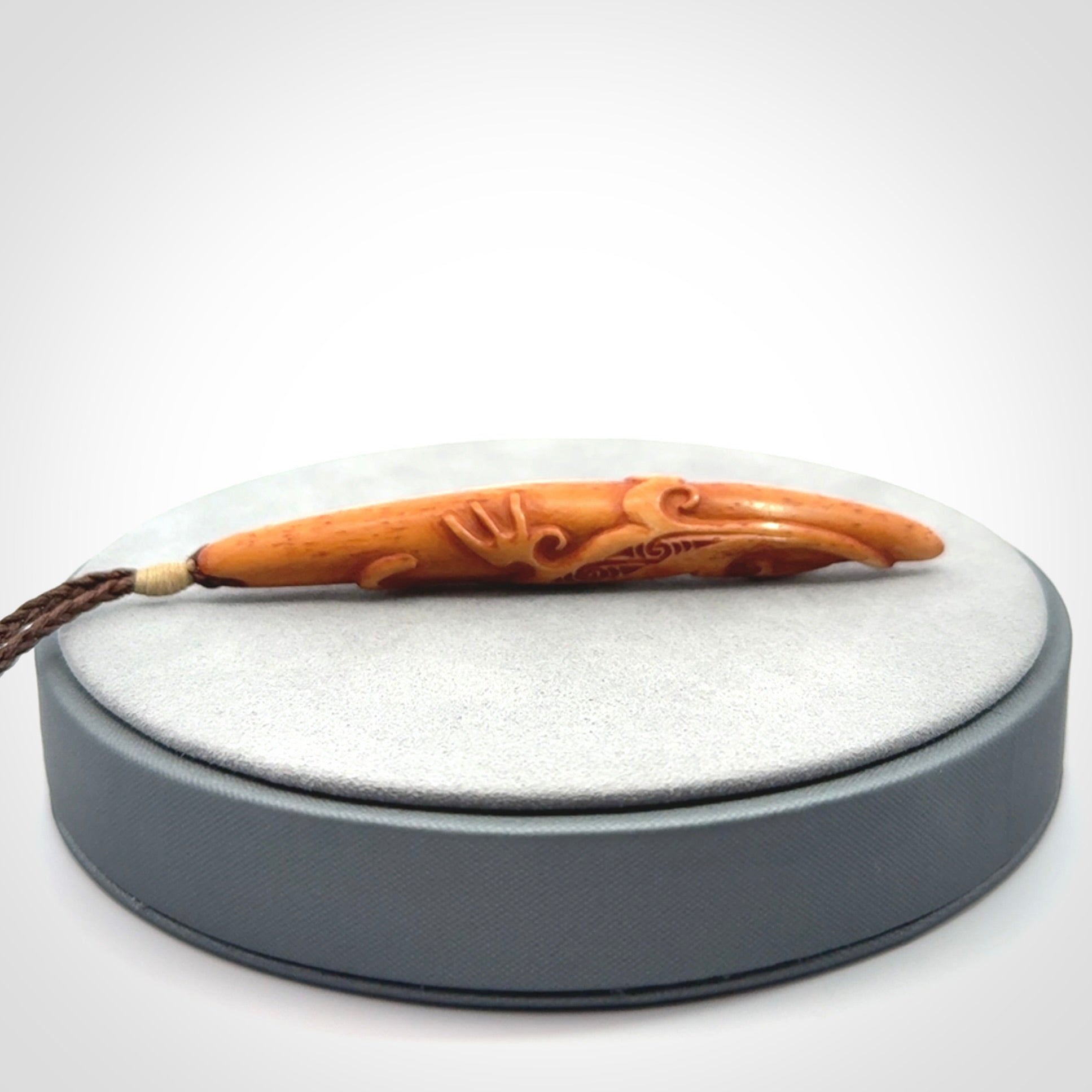 Bone carving of a lizard climbing. A three dimensional pendant carved in bone by Yuri Terenyi.
